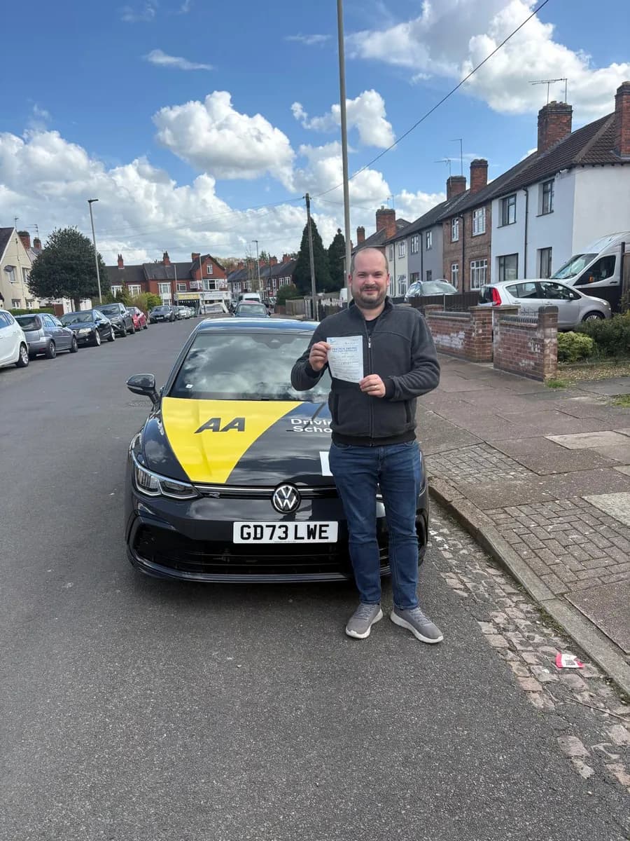 Lewis celebrating with his UK practical driving test pass certificate after manual lessons with Maurizio Gobbato at DrivePro Midlands